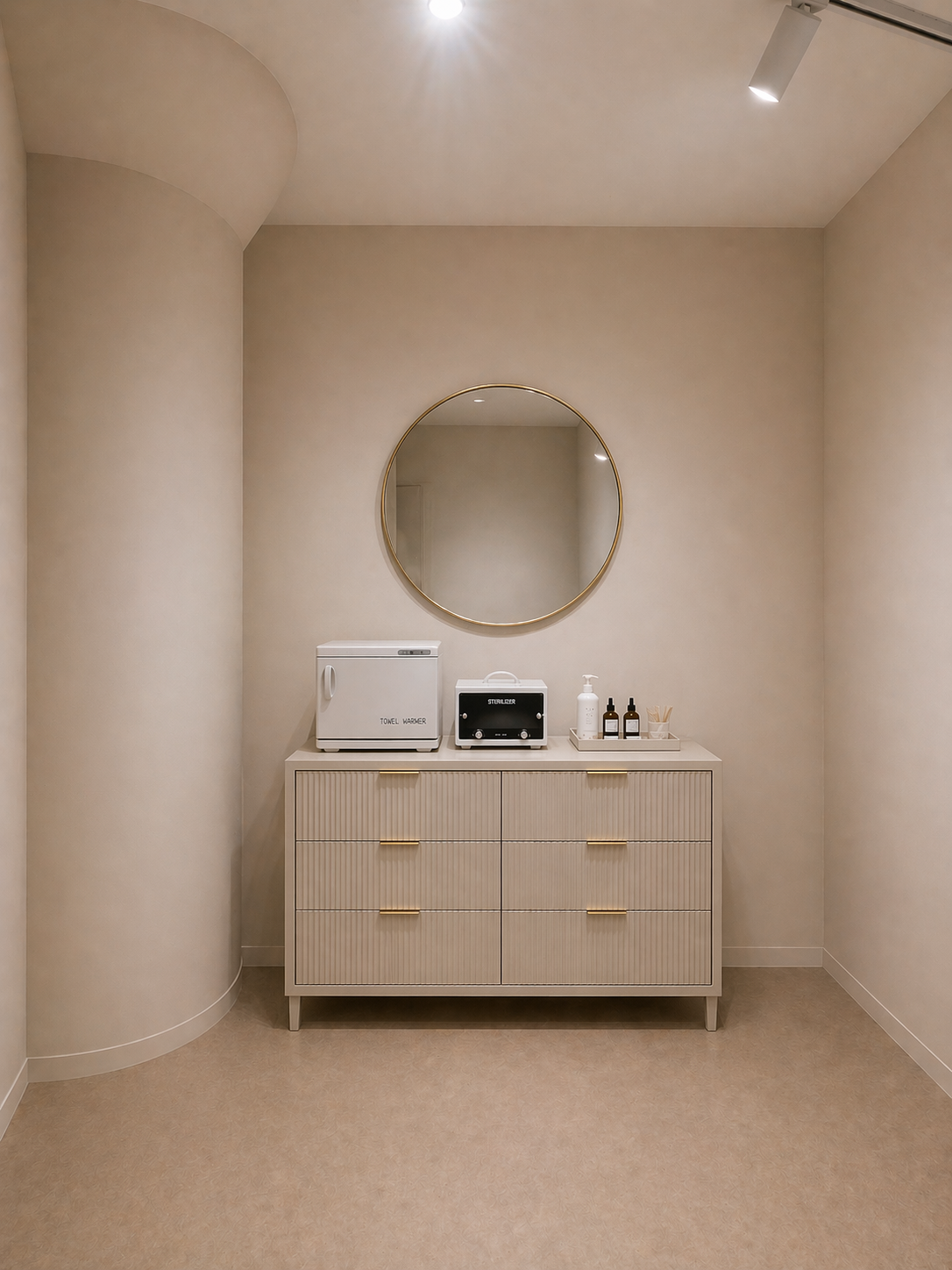 Facial & Waxing detail: a fluted dresser with towel warmer, UV sterilizer, product tray, and a round gold mirror.