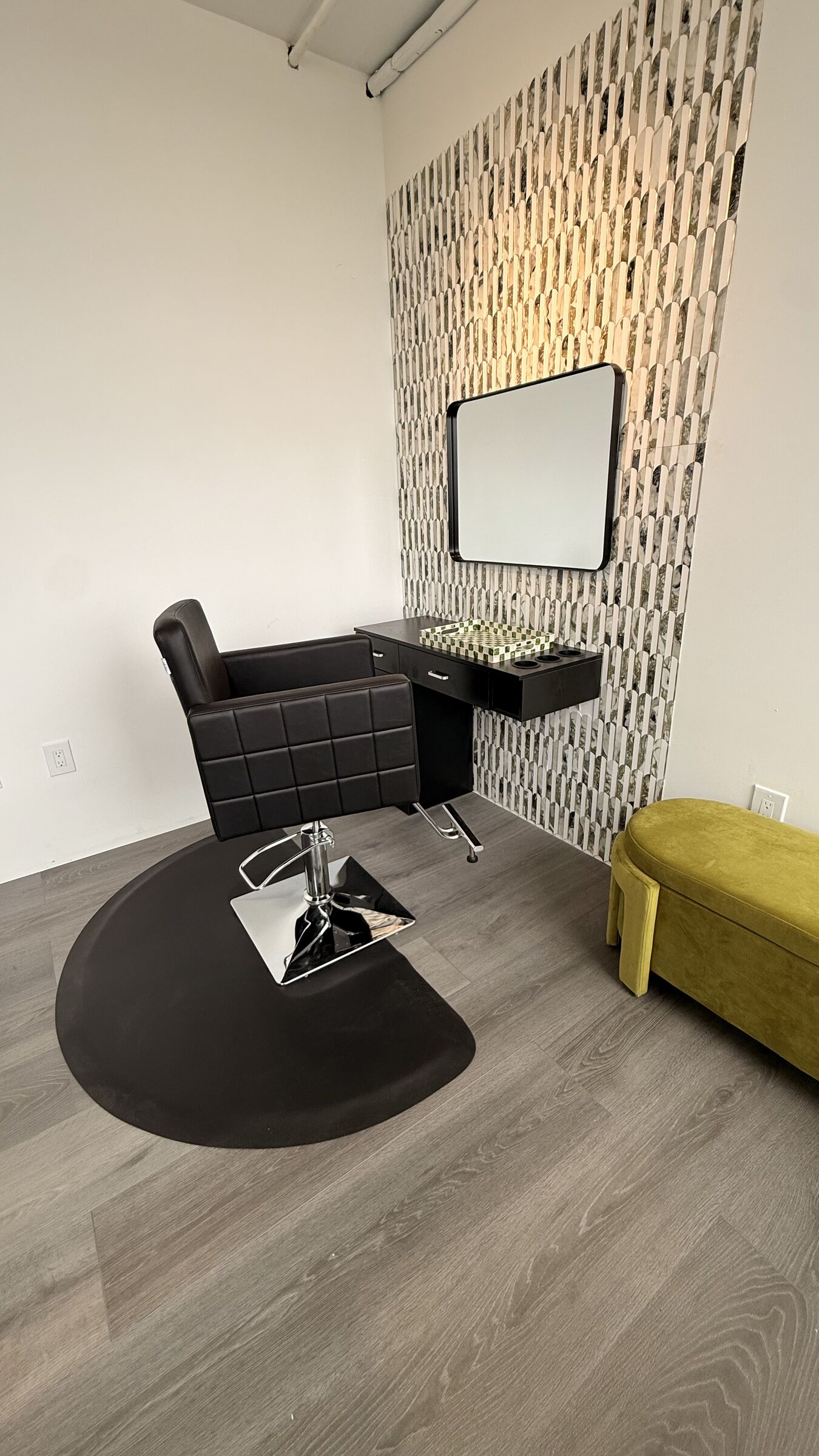Hair Studio: vertical editorial view of a single styling station with mosaic feature wall and yellow velvet bench.
