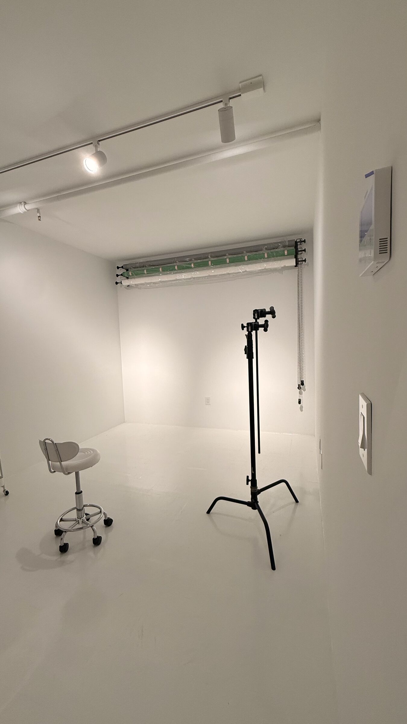 Portrait Studio vertical: backdrop rolls, C-stand, track lighting, and swivel stool — the clean pro-studio composition.